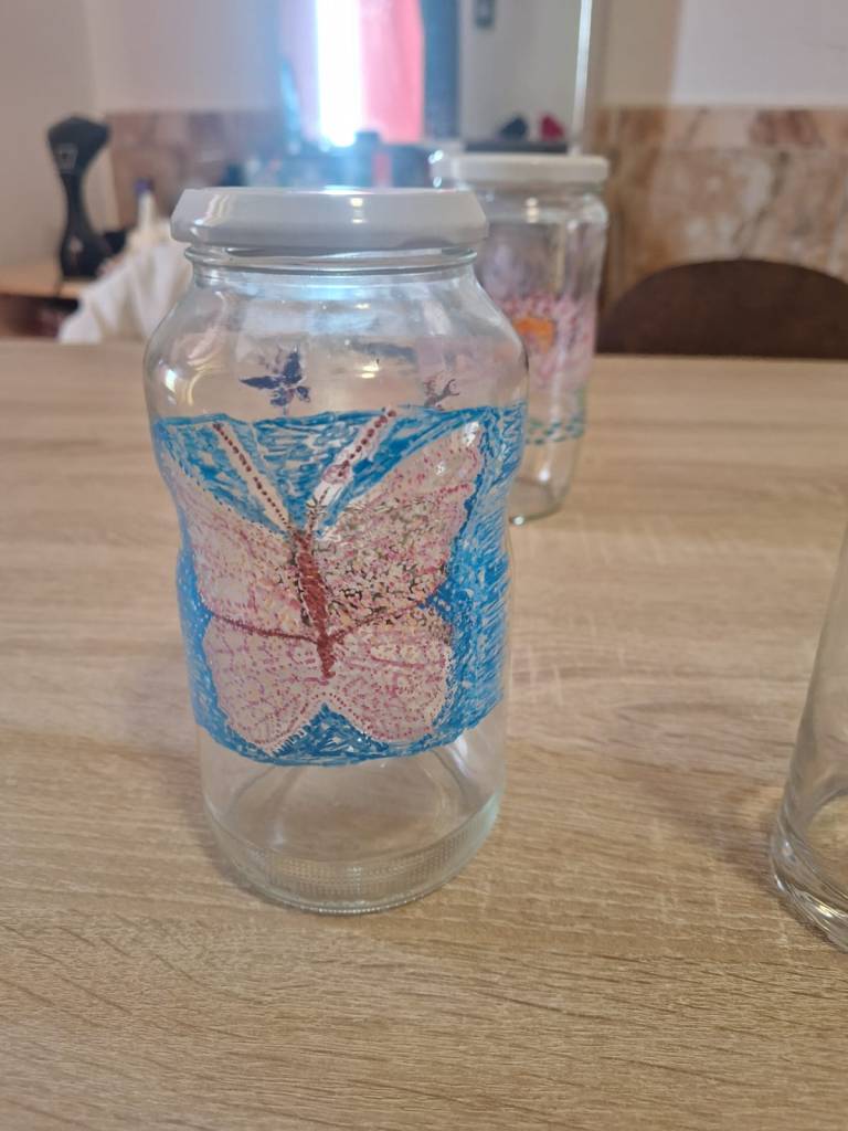 bocal représentant deux face un papillon et un livre.